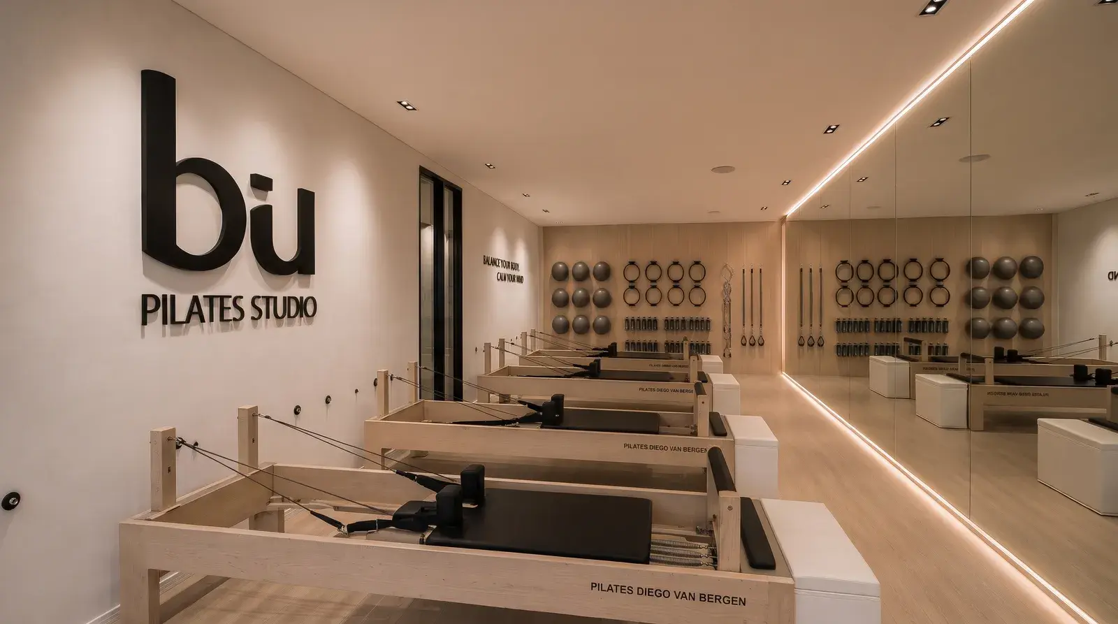 Sala de reformers con el logo de Be U Pilates Studio